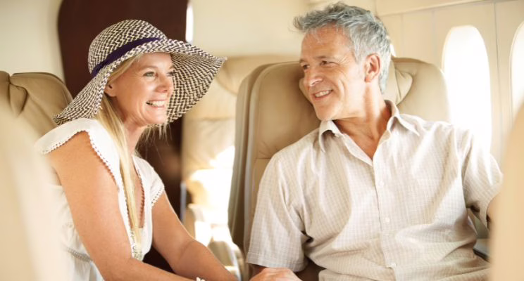 Smiling couple talking in the leather seats of a private jet cabin